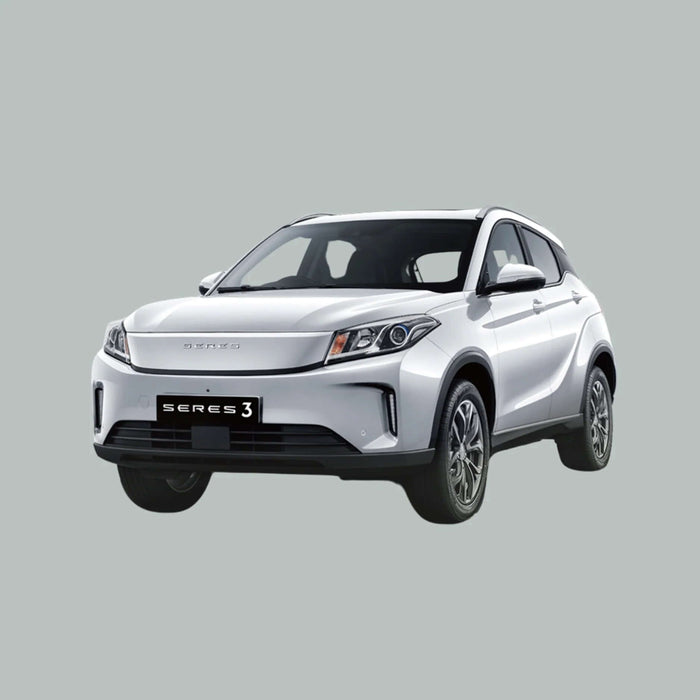 Een zilverkleurige Seres 3 elektrische SUV is afgebeeld op een effen grijze achtergrond, gezien vanuit de hoek linksvoor. De auto heeft strakke koplampen, een moderne grille en zwarte sierstrips op de onderbumper.