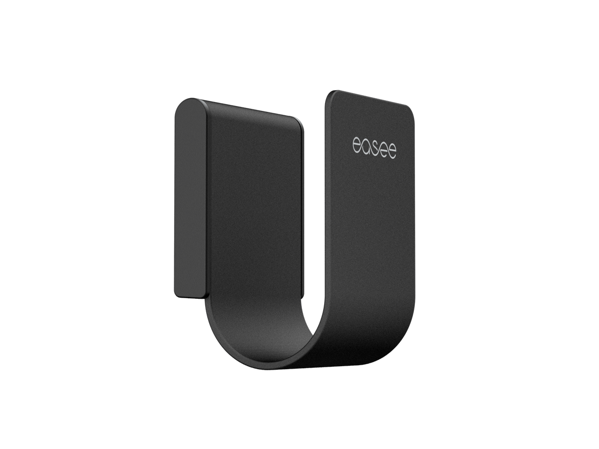 Een zwarte Easee kabelhouder uit de Easee kabelhouder Wit/Rood/Zwart/Chrome serie, minimalistisch vormgegeven met een afgeronde onderkant, gemaakt van roestvrij staal en met "easee" in wit gedrukt op de bovenzijde. Ideaal voor het opbergen van een laadkabel.