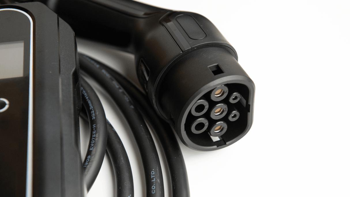 Close-up van een Thuislader stopcontact type 2 3-fase 8A-16A (5,5kW-11kW) laadstekker met dikke zwarte kabel voor je elektrische auto, perfect voor gebruik met een EV lader of thuislader, liggend op een witte ondergrond.