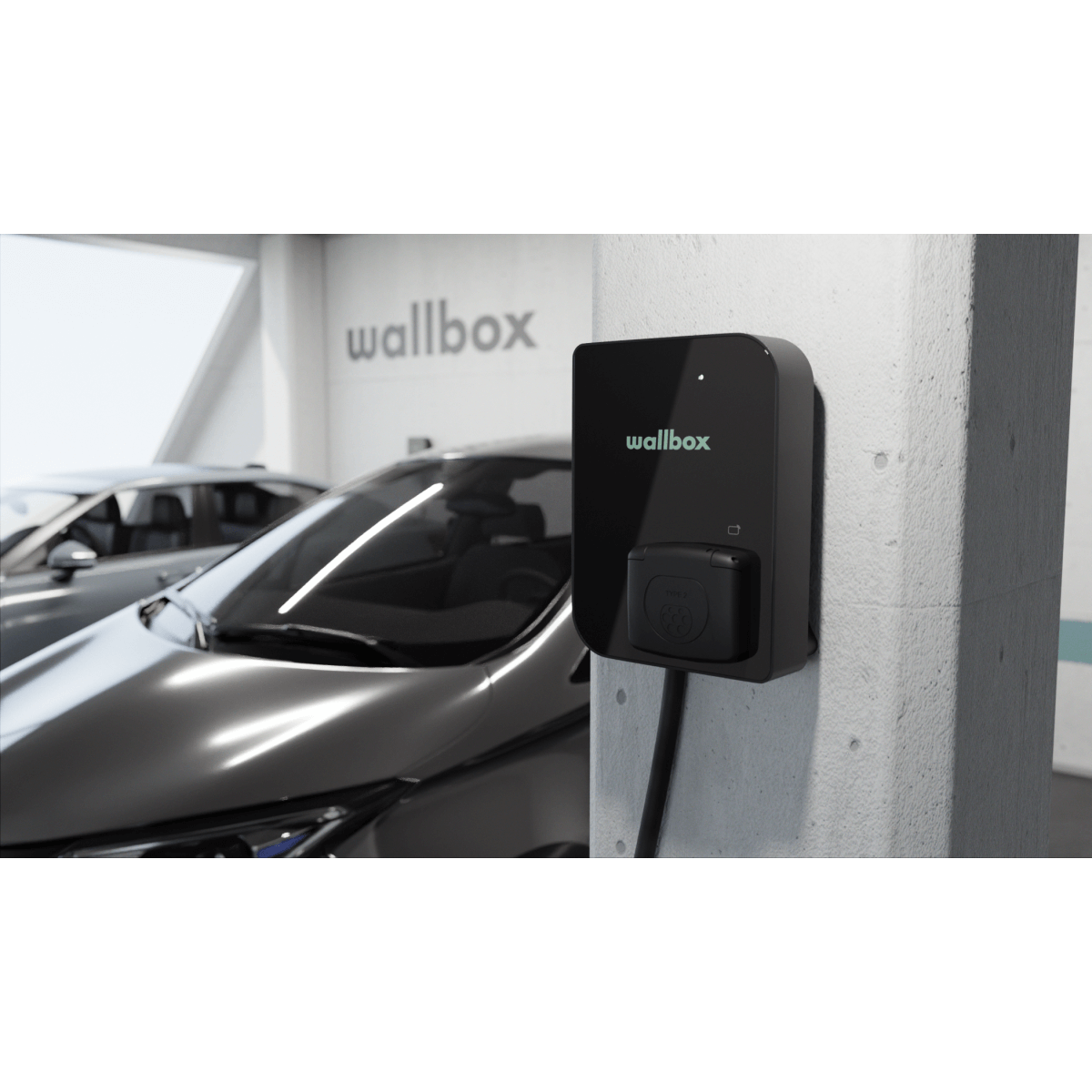 Een Laadstation Wallbox Copper SB 22kW type 2 aansluiting is gemonteerd op een witte pilaar in een parkeergarage, met een grijze auto in de buurt en het woord "wallbox" zichtbaar op de muur op de achtergrond.