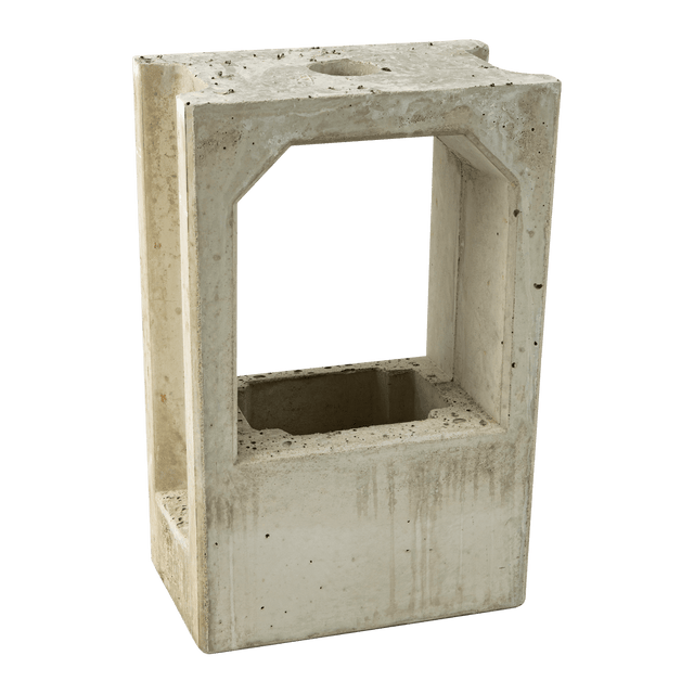 De Alfen Betonnen voor Eve laadpaal sokkel voor montagepaal is een holle, rechthoekige betonnen sokkel met strakke randen en een open midden. Het oppervlak heeft kleine vlekken en imperfecties, wat wijst op blootstelling aan de elementen.