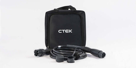 Een zwarte CTEK-draagtas zit achter een opgerolde CTEK Laadkabel type 2 naar type 1 SAE J1772 1-fase 32A met twee zwarte connectoren en beschermkappen, alles tegen een witte achtergrond.