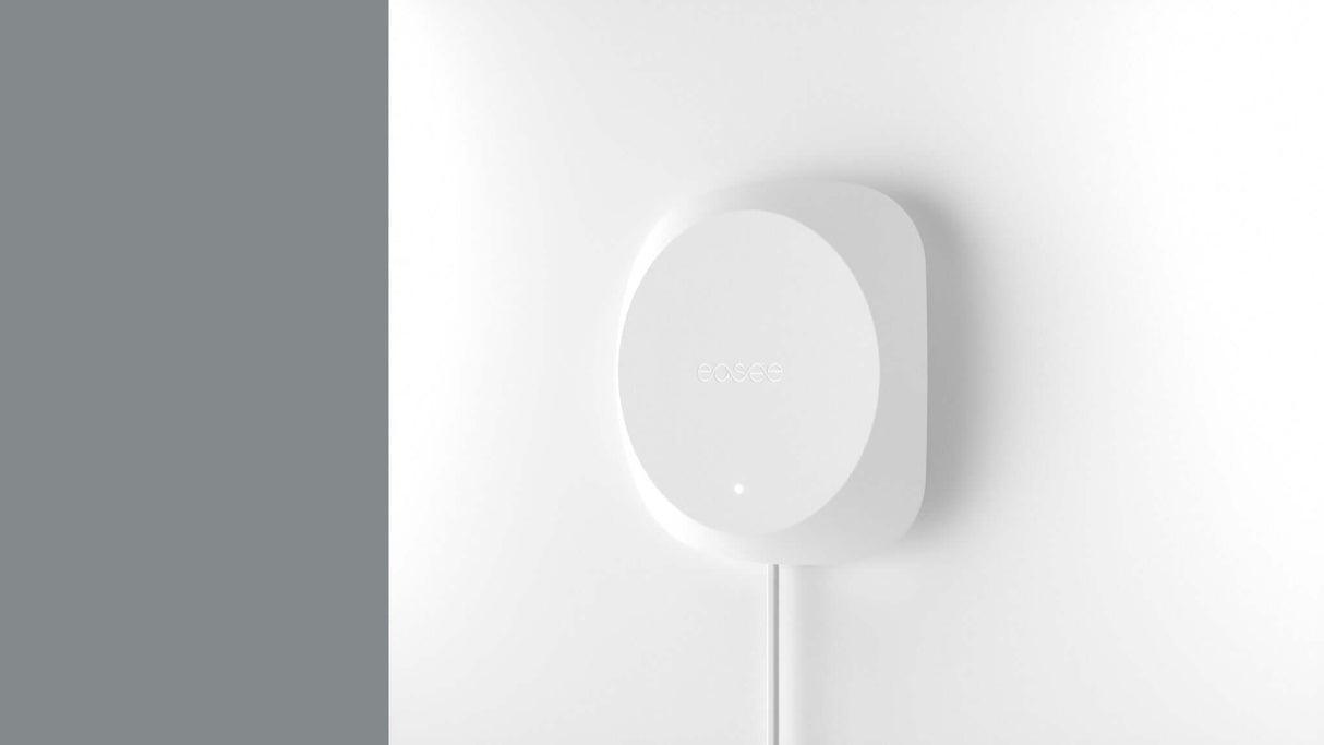 Een minimalistisch wit smart home-apparaat met het ecobee-logo is gemonteerd op een witte muur en bevestigd via een enkele kabel - perfect voor load balancing bij gebruik met de Easee Equalizer Load balancing voor P1 poort van slimme meter.