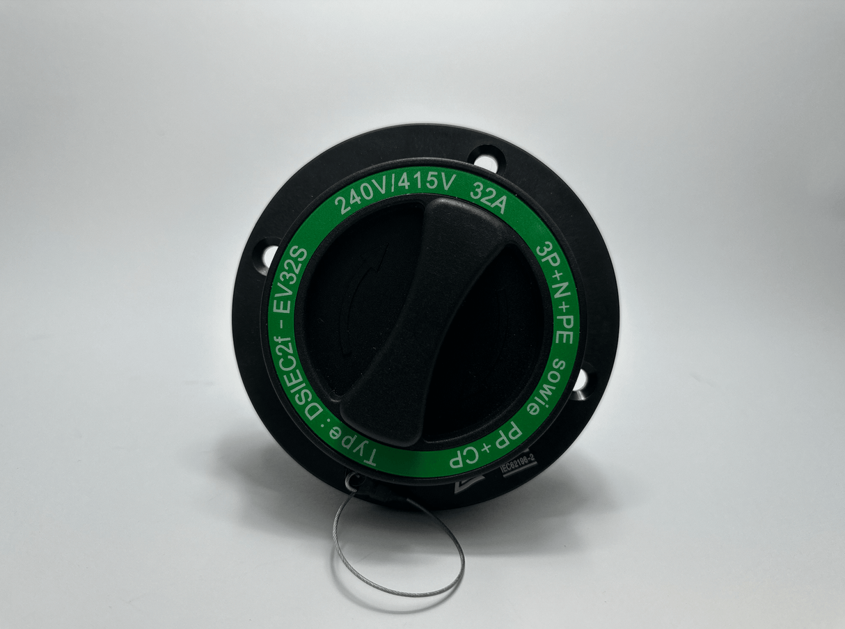 Een Type 2 Inlaat 16A/32A Knijpverbinding draaischakelaar in zwart met een groen 240V/415V 32A 3P+N+PE label is afgebeeld op een witte achtergrond. Een metalen ring aan de onderkant past op de 16A/32A aansluiting.