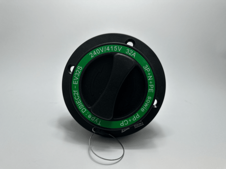Een Type 2 Ingang 16A/32A Knijpverbinding zwart en groen industriële elektrische schakelaar, gelabeld 240V/415V 32A, 3P+N+PE met draaibare hendel en metalen ring, gefotografeerd op wit. Inclusief een 16A/32A aansluiting voor veelzijdige stroomaansluitingen.