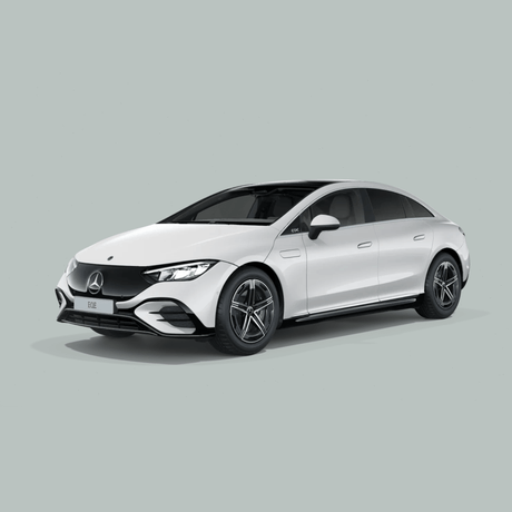 Een witte Mercedes-Benz elektrische sedan staat geparkeerd op een effen lichtgrijze achtergrond, gezien vanuit de hoek linksvoor. De auto heeft strakke lijnen en een moderne styling.