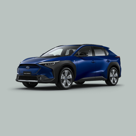 Een blauwe Subaru Solterra elektrische SUV staat geparkeerd op een effen, lichtgrijze achtergrond, getoond vanaf de voorkant.