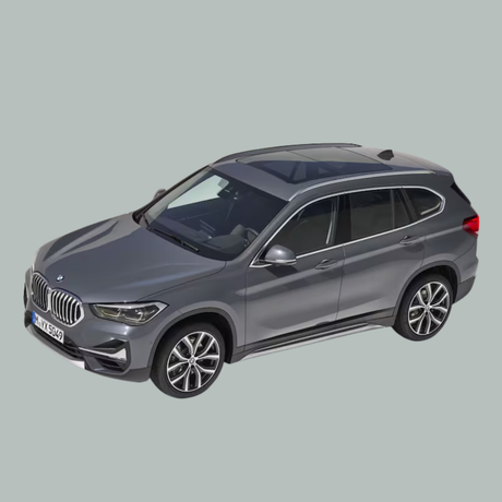 Een grijze BMW SUV wordt getoond vanuit een verhoogde hoek tegen een effen, lichtgrijze achtergrond. De auto heeft een zonnedak, zwarte bekleding en een moderne styling.