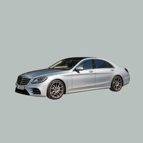 Een zilveren luxe sedan met een gestroomlijnd ontwerp wordt weergegeven op een effen lichtgrijze achtergrond.