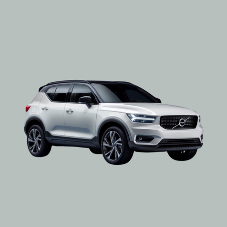Een zilverkleurige Volvo XC40 SUV is afgebeeld op een effen, lichtgrijze achtergrond, gezien vanaf de linker voorkant.