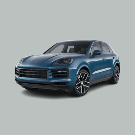 Een blauwe Porsche SUV staat geparkeerd op een effen, lichtgrijze achtergrond, gezien vanuit een driekwart vooraanzicht. De auto heeft strakke koplampen en een moderne, sportieve styling.