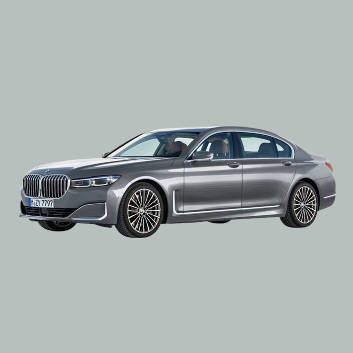 Een zilverkleurige BMW luxe sedan staat geparkeerd op een lichtgrijze achtergrond, bekeken vanuit een lichte hoek aan de voorkant, waarbij de grote grille, de gestroomlijnde koplampen en de gedetailleerde lichtmetalen velgen goed tot hun recht komen.