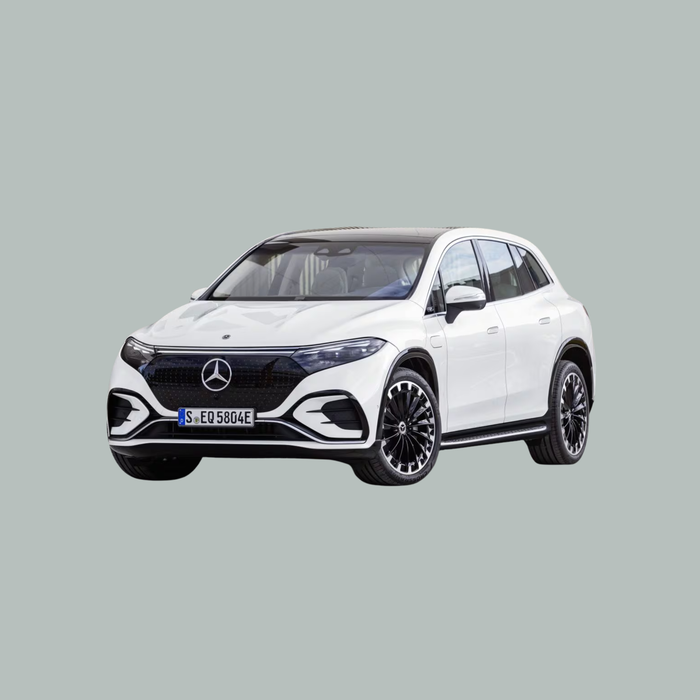 Een witte Mercedes-Benz elektrische SUV met zwarte accenten en lichtmetalen velgen is afgebeeld op een effen, lichtgrijze achtergrond, iets naar links gericht.