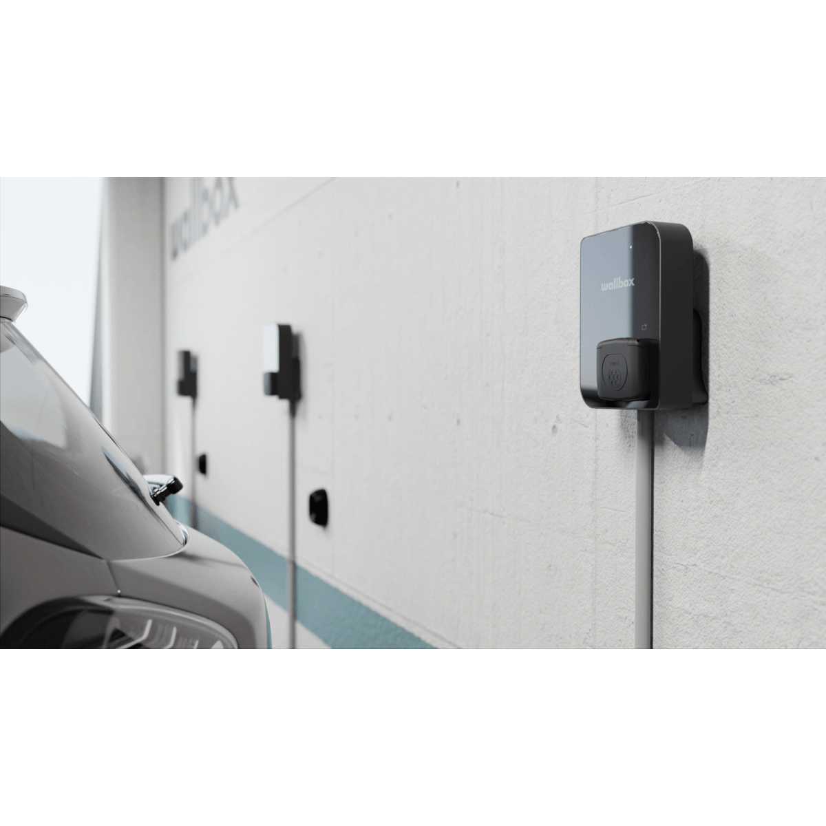 Een close-up van een elektrische auto die is aangesloten op een Laadstation Wallbox Copper SB 22kW type 2 aansluiting, met meer laadstations in een rij langs de muur op de achtergrond.